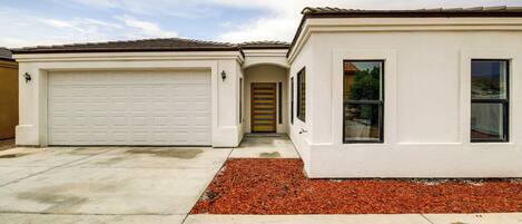 A two-story house with a garage, a front door, and a small porch area.