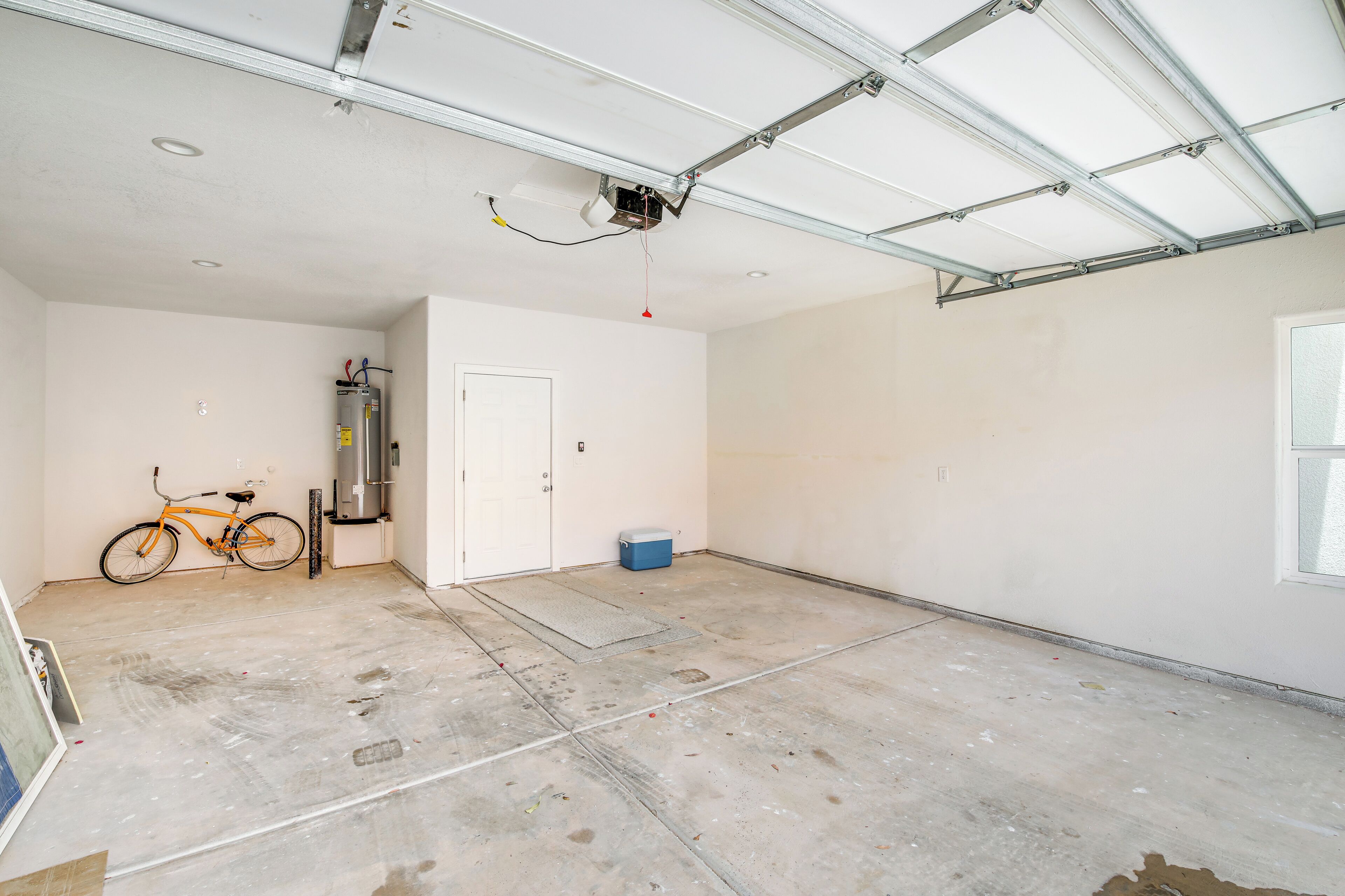 A spacious garage with a bicycle, a water dispenser, and a door.