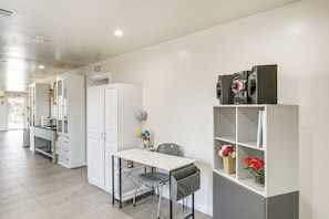 Guest room with a desk, wardrobe, and shelving unit.