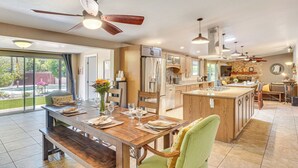 A spacious kitchen with a large island, wooden cabinetry, and a dining area with a bench. - Dog-Friendly Getaway w/ Patio in Tucson! (Tucson)