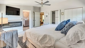 A bedroom with a large bed, a ceiling fan, a TV mounted on the wall, and a walk-in closet. - Dog-Friendly Getaway w/ Patio in Tucson! (Tucson)