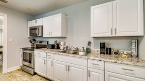 A modern kitchen with white cabinets, stainless steel appliances, and a granite countertop. - 3 Mi to Beach: Family Home in Corpus Christi! (Corpus Christi)