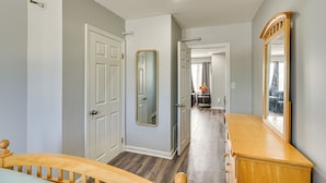 A hallway with a wooden bench, a door with a mirror, and a dresser with a mirror. - 2 Mi to Waterfront: Walkable Fall River Apartment! (Fall River)