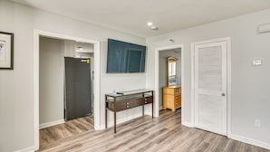 A room with a wooden floor, a glass-top desk, a mirror, and a white door. - 2 Mi to Waterfront: Walkable Fall River Apartment! (Fall River)