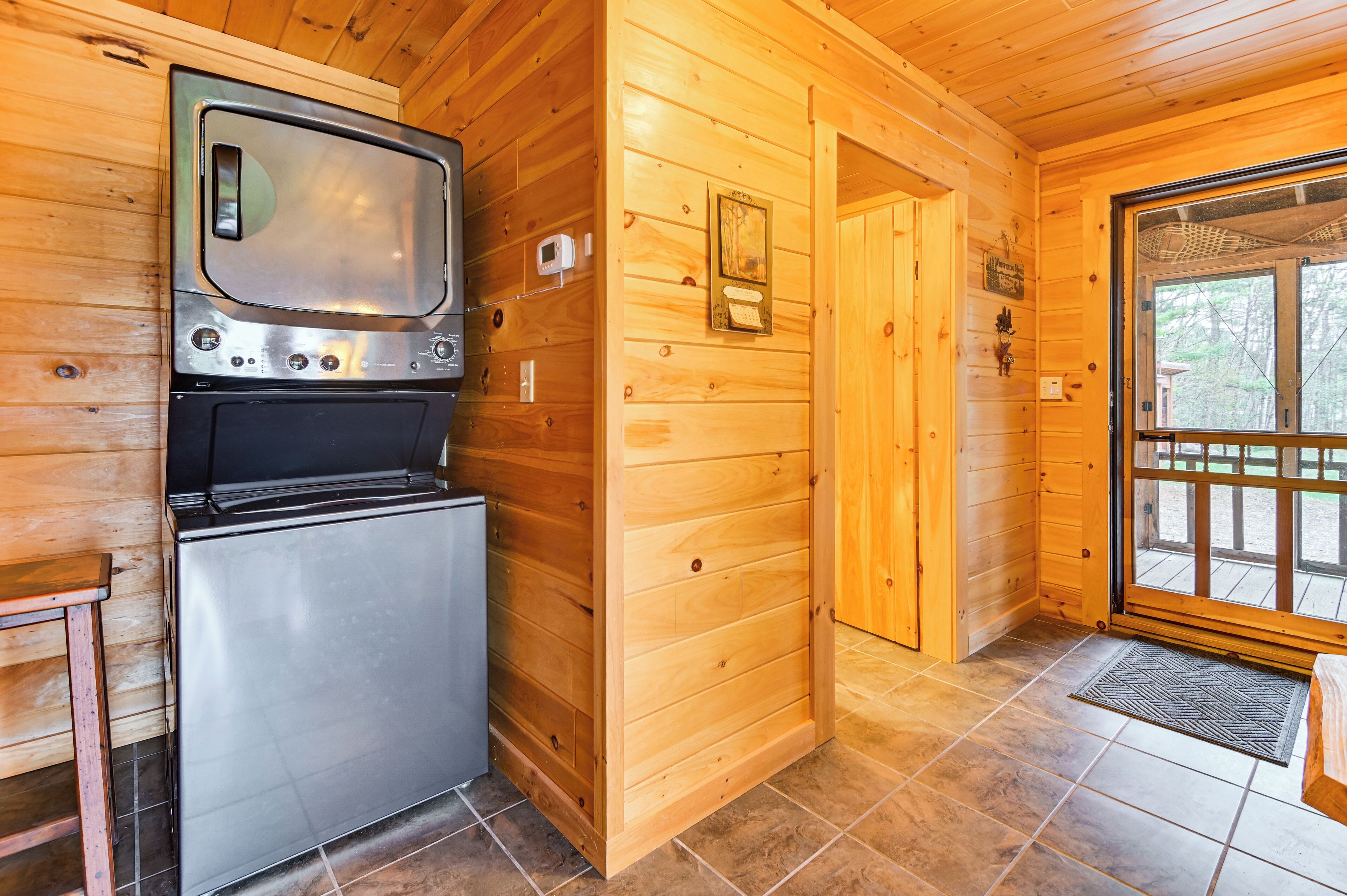 A compact kitchen with a stainless steel refrigerator, a built-in oven, and a microwave.