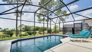 Una piscina techada con vistas despejadas del paisaje circundante, que incluye árboles y un edificio distante.