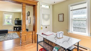 A living room with a wooden floor, a white door, a window with blinds, a TV, and a bookshelf. - Near Nockamixon State Park: Telford Apt w/ Porch! (Telford)