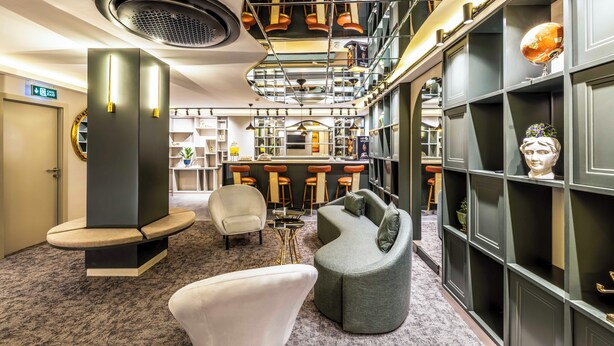 Un interior moderno con una zona de bar, asientos y una escalera.