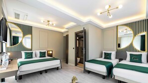Habitación de hotel con dos camas, un escritorio y un espejo.