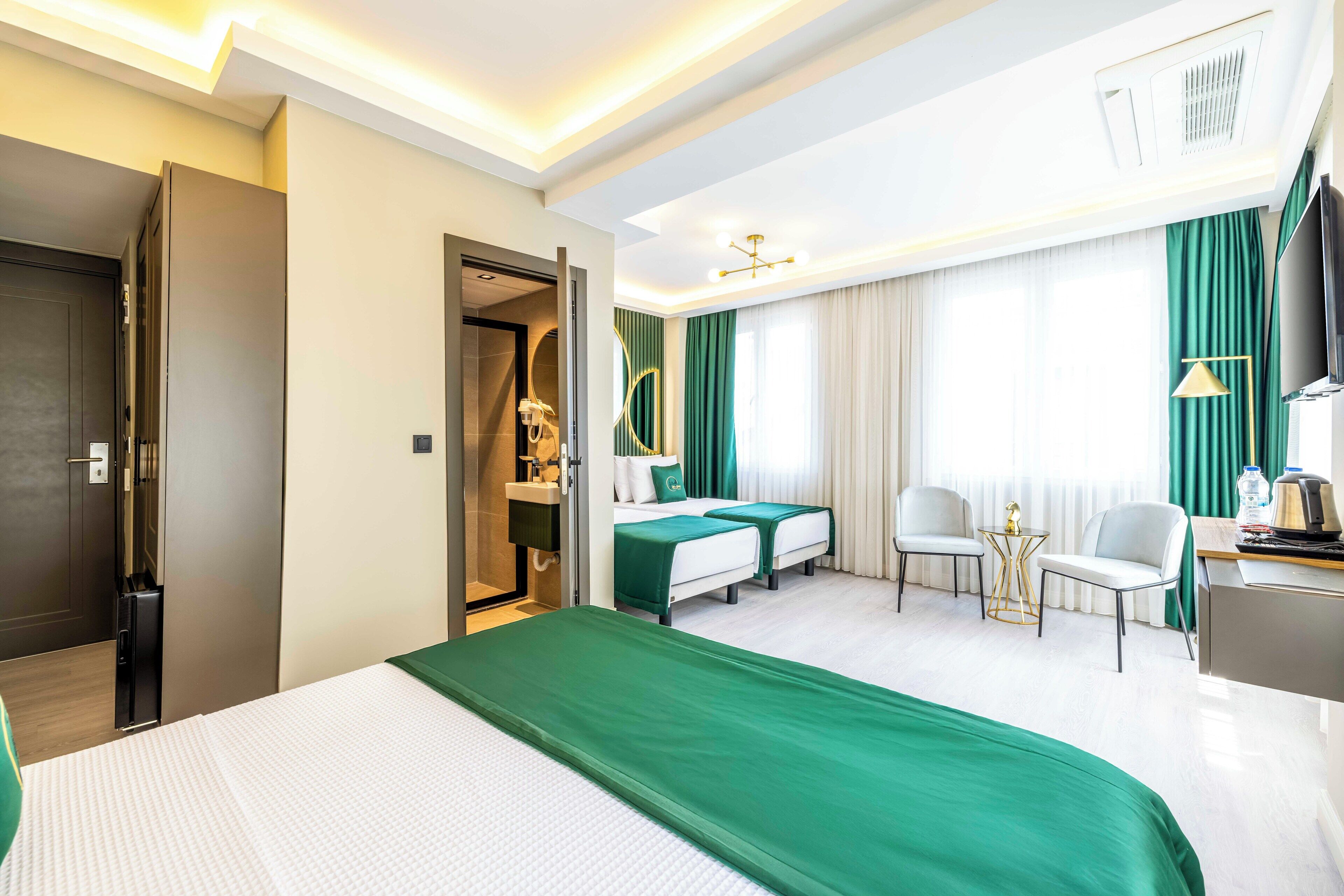 A hotel room with a bed, two bedside tables, a desk, a chair, a TV, and a bathroom.
