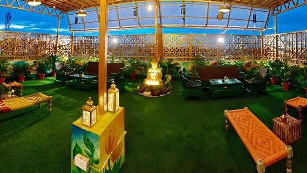 An indoor garden with seating areas, a central fountain, and a decorative fence.