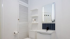 Ein kleines Badezimmer mit Toilette, Waschbecken und Spiegel.