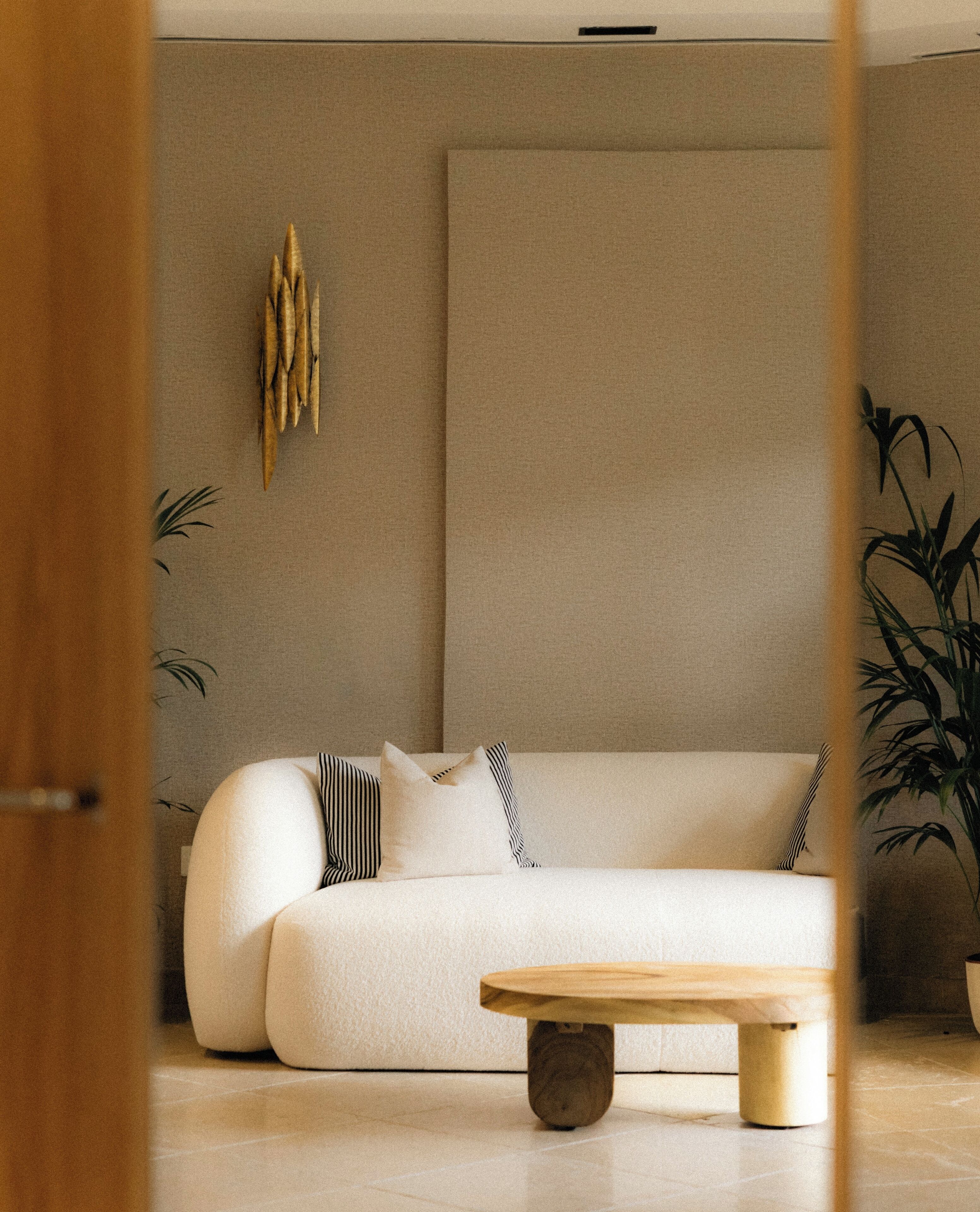 A modern living room with a sofa, a coffee table, and a wall-mounted light fixture.