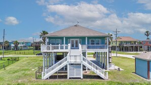 A two-story building with a balcony, a staircase, and a small porch area.