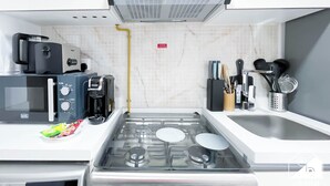 A compact kitchen with a microwave, toaster, and gas stove. - JVC Hideaway: Studio With Balcony and Amenities (Dubai)
