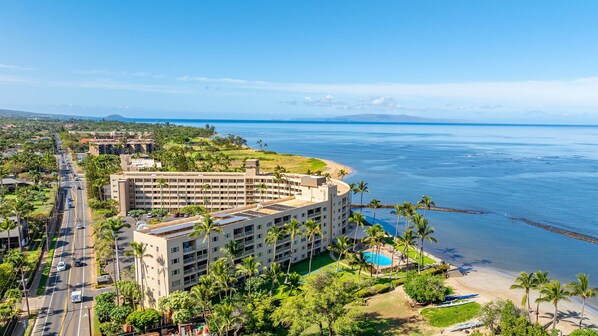 A hotel with multiple floors, a swimming pool, and a beachfront view.