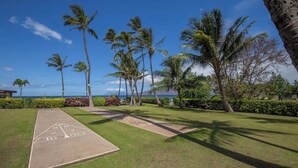 A shuffleboard court with a clear view of the ocean and palm trees in the background. - FALL SPECIAL!! PREMIUM OCEANFRONT UNIT WHER THE OCEAN MEETS THE SKY!!! (Kihei)