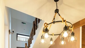 A staircase with wooden railings and a modern chandelier. - Casa Danciu Fanate – Tradiție, liniște și ospitalitate în inima naturii (Cernești)