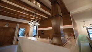 A modern interior with wooden beams, a central column, and a reception desk. - Casa Danciu Fanate – Tradiție, liniște și ospitalitate în inima naturii (Cernești)
