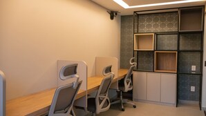 Ein Konferenzraum mit einem langen Tisch, drei Stühlen und eingebauten Regalen mit einem geometrischen Muster.