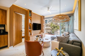 A modern living room with a sofa, a coffee table, and a TV mounted on a wooden wall.