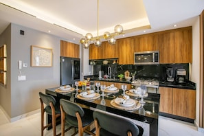 A modern kitchen with a central island, wooden cabinets, and stainless steel appliances. - Romantic Zone 2BR | Rooftop Pool, Bar & Views (Puerto Vallarta)