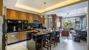 A modern kitchen with a central island, wooden cabinets, and a dining area with chairs and a table set for a meal.