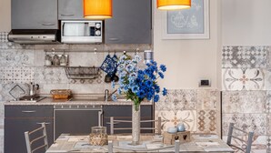 Una cocina moderna con armarios grises, un microondas y un florero con flores azules.
