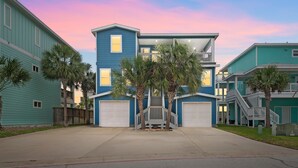 A two-story residential building with a central staircase, a garage, and a small porch area.