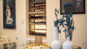 Een eettafel met een bord koekjes, een kleine schaal en twee vazen met blauwe bloemen.