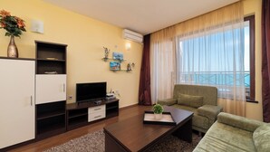 A modern living room with a flat-screen TV, a sofa, a coffee table, and a cabinet.