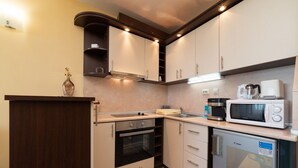 A compact kitchen with a built-in oven, microwave, and dishwasher.