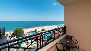 A balcony with a view of a beach and ocean.