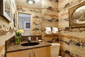 A bathroom with a granite countertop, a sink, a mirror, and a toilet. - 700 Ute Apartment #703 4 Bedroom Home (Aspen)