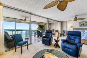 Relax on the balcony with ocean views, featuring a seating area with a comfortable armchair and coffee table.