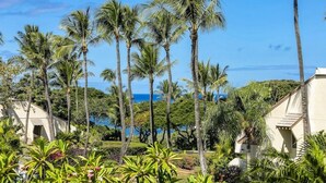 Un resort con palmeras, piscina y vista al océano.