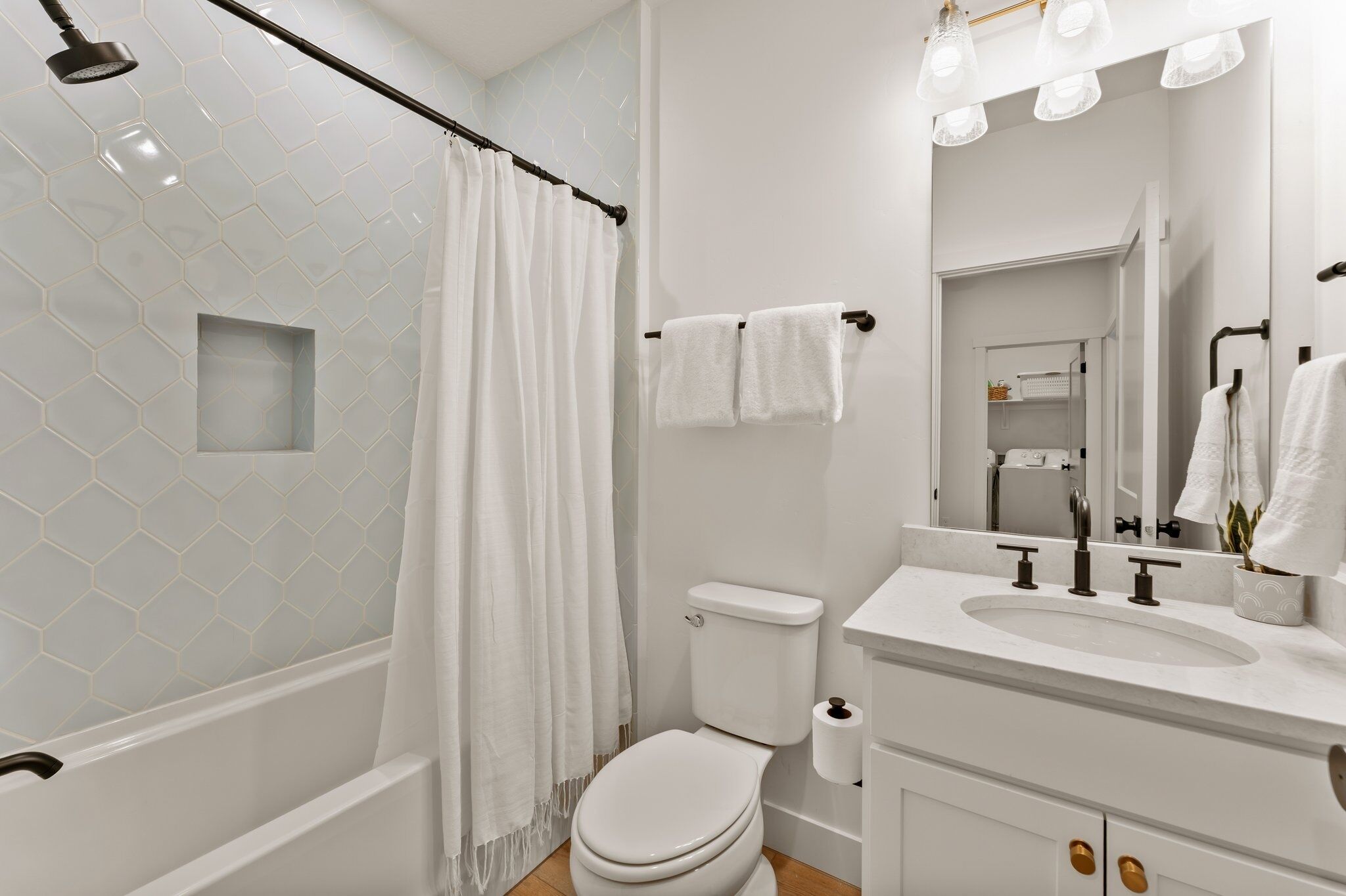 A modern bathroom with a shower, toilet, and sink.
