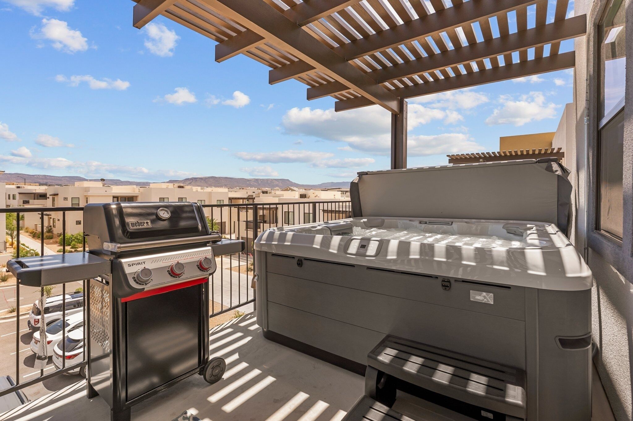 A rooftop patio with a grill and a hot tub.