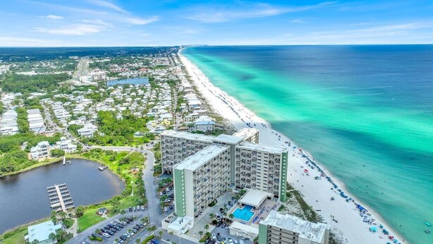 Un hotel costero con varias edificaciones, una playa y un puerto deportivo.
