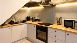 Una cocina moderna con horno integrado, cafetera y microondas.