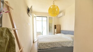 Una camera da letto con un letto, una lampada a sospensione e una porta che dà su un balcone.