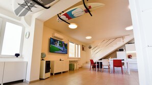 Una cucina moderna con mobili bianchi, una zona pranzo con sedie rosse e una scala che conduce a un altro piano.