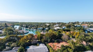 A coastal resort with multiple buildings, a large pool area, and a view of the sea.