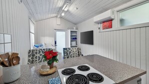 A kitchen with a granite countertop, white stove, and wooden utensils.