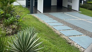 Una casa moderna de dos pisos amb teulada plana i grans finestres.