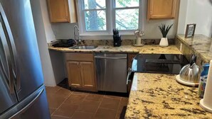 A kitchen with granite countertops, stainless steel appliances, and wooden cabinets. -  Cozy Cape Cod in lovely Allentown with modern amenities (Allentown)