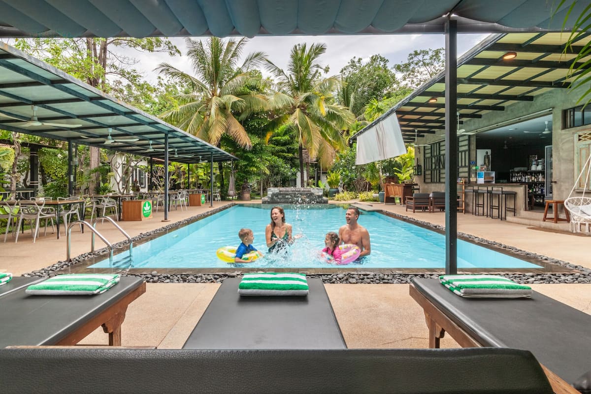 Piscina com espreguiçadeiras e área de bar.