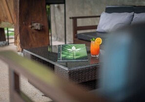 A menu on a table with a glass of orange juice garnished with a mint leaf and an orange slice. - Banana Resort le Petit nid de Caro (Siem Reap)