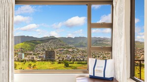 Vista desde una ventana, con una bolsa con la etiqueta 'Castle & Resorts' sobre una mesita de noche de madera.