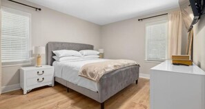 Cozy retreat with a central bed, nightstand, and dresser, perfect for a restful stay.
